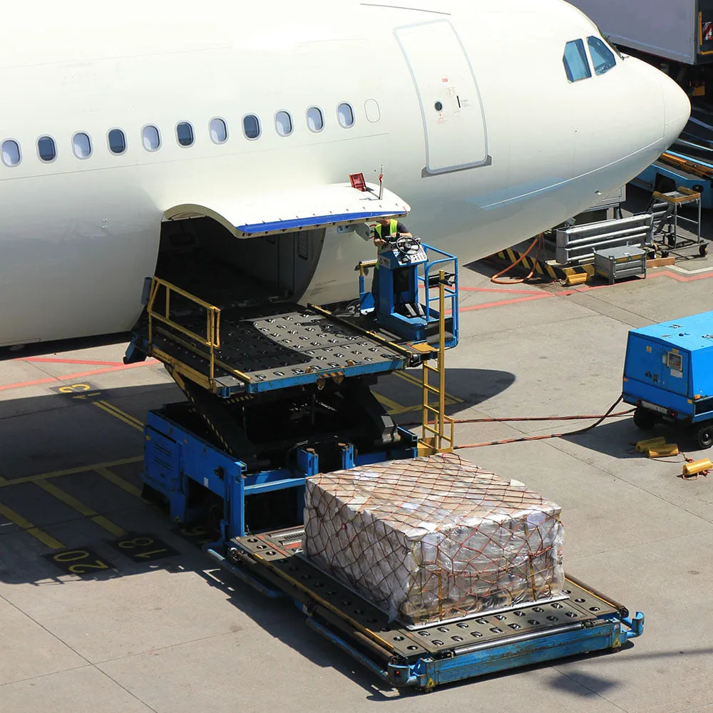 Freight place cargo being loaded onto air freight plane at shipping dock